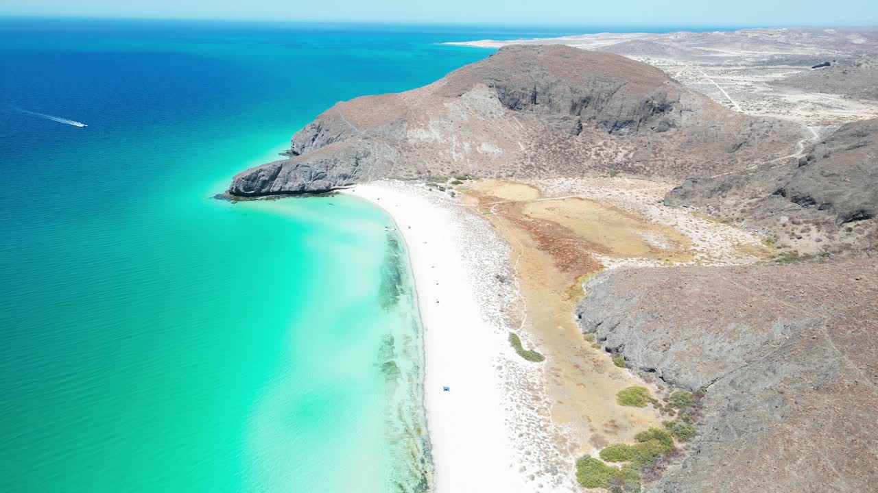 Beach view of La Paz, Tecolandra, Mexico with clear blue waters, hills, and sandy coastline