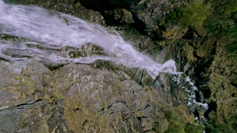 Cinematic-view-along-fresh-flowing-waterfall-down-the-steep-hill