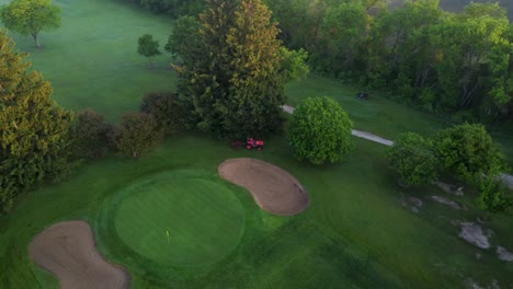 drone footage of preparing golf course for playing in early morning sunrise