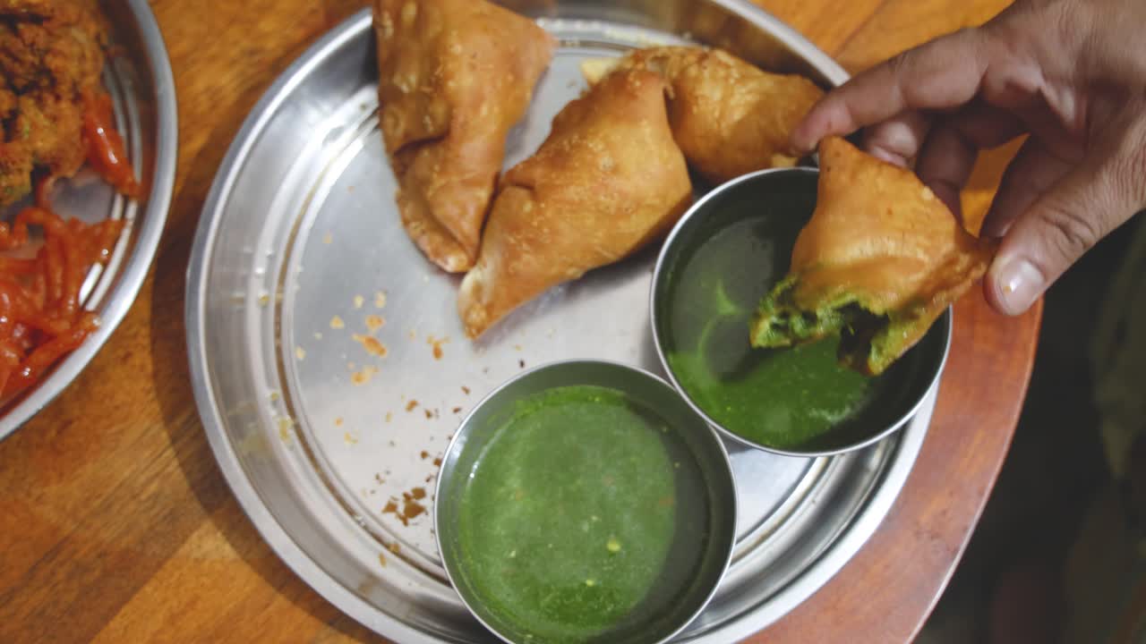 group relishing traditional samosa snack with chutney