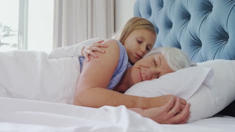 nieta afectuosa besando a la abuela en el dormitorio 4k