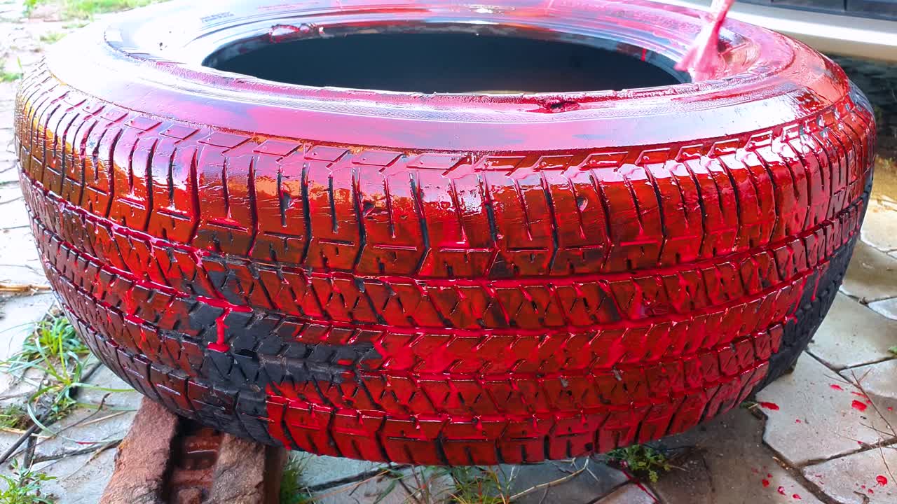 Riutilizzo di un vecchio pneumatico d'auto abbandonato come fioriera.