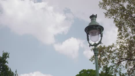 static view of typical french street lamp on partially cloudy summer day in paris, france