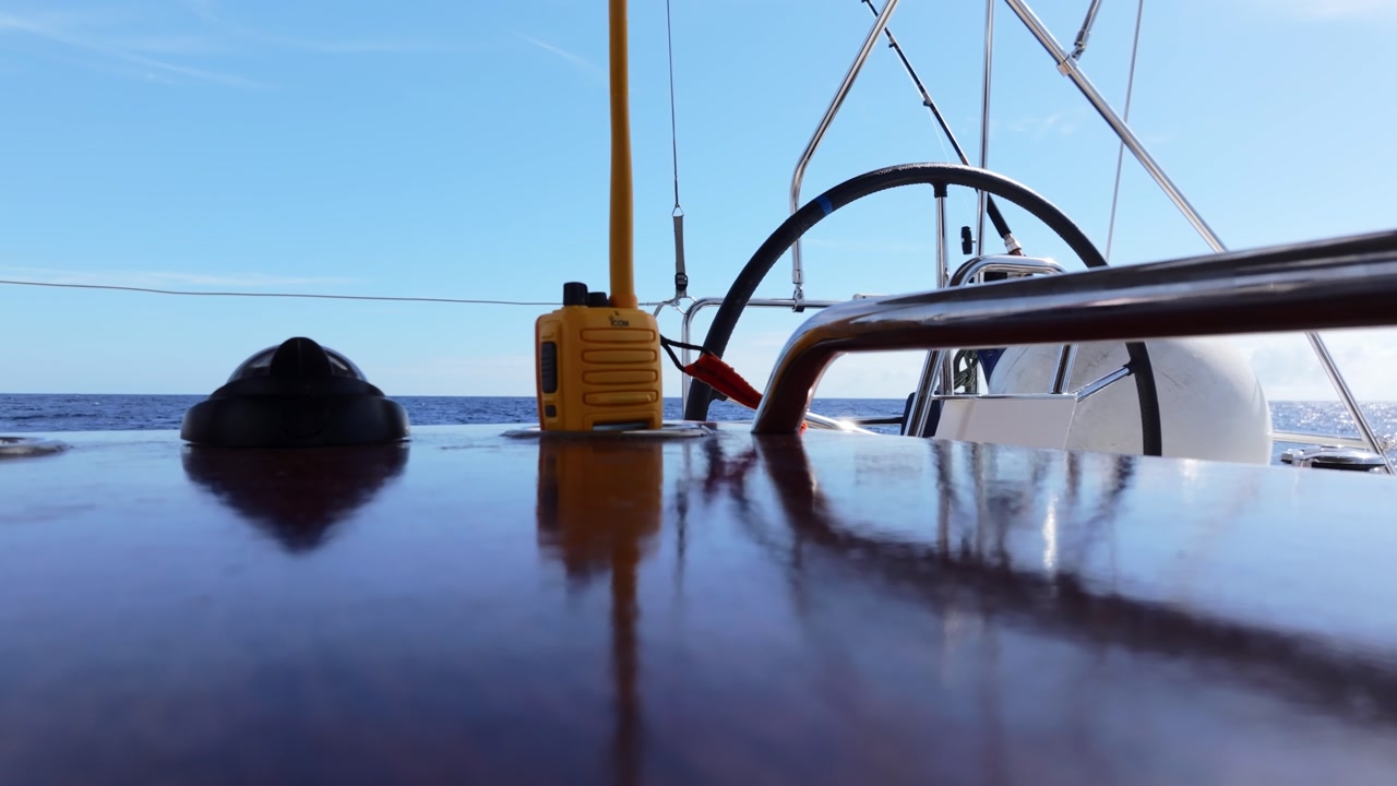 Marine radio and yacht wheel close-up during sailing across deep sea