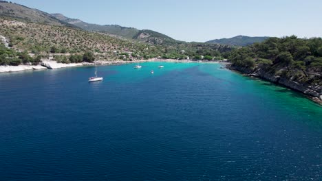 drone view of aliki beach with turquoise water and mountains covered by lush vegetation in the background, thassos island, greece