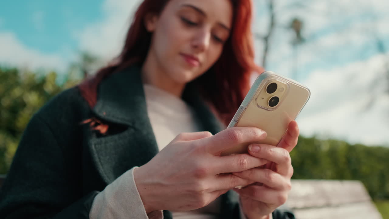 Giovane donna che usa lo smartphone all'aperto in un parco