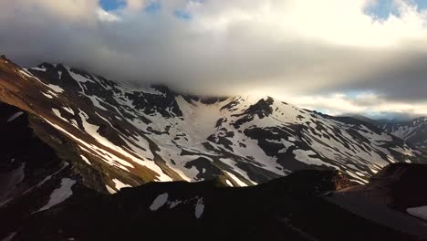 Aerial-view-of-austrian-mountains-snowy-peaks-touching-the-cloudscape