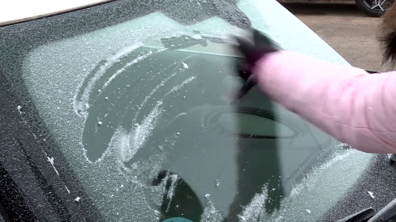 Scraping Ice off a Frozen Car Windshield