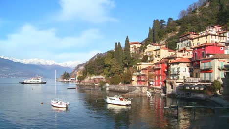 las hermosas orillas del lago de como con la ciudad de varenna y los alpes italianos al fondo