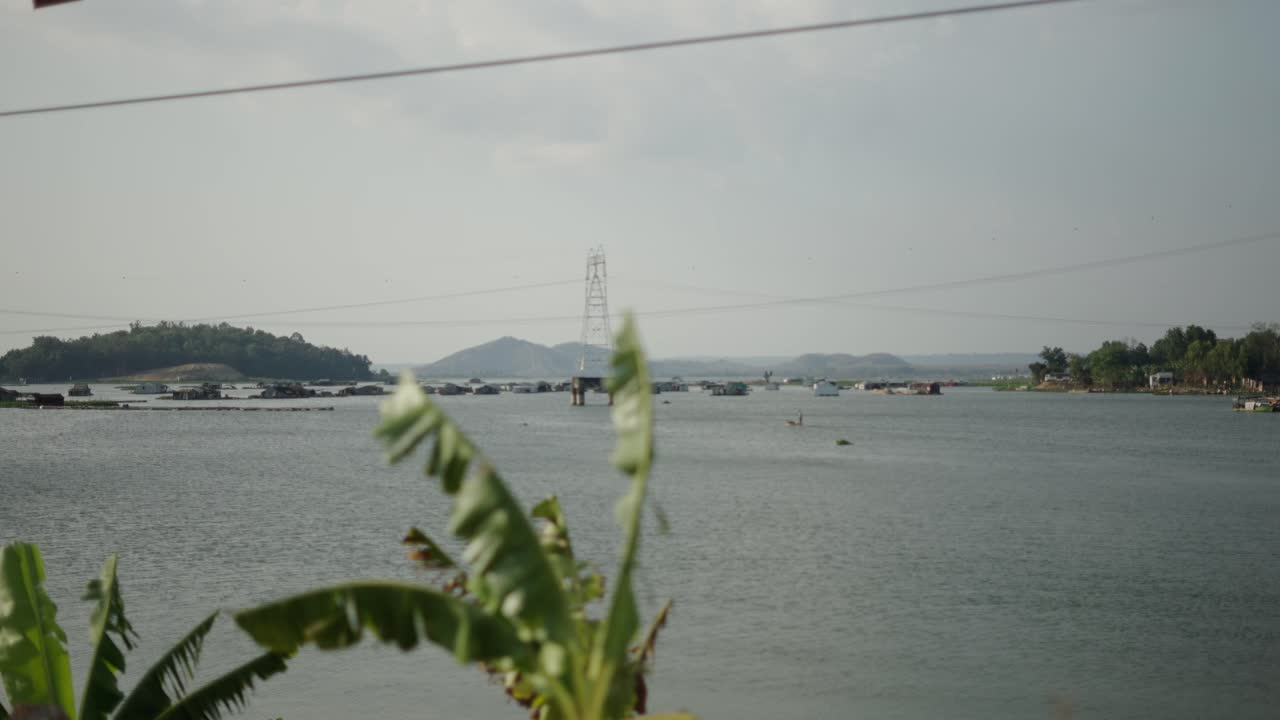 River Scene with Village and Electricity Pylon