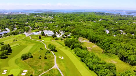 Forward-moving-aerial-of-golf-course,-all-enveloped-in-serene-dense-greenery