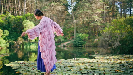 magical princess posing lake covered water lilies. forest nymph standing pond