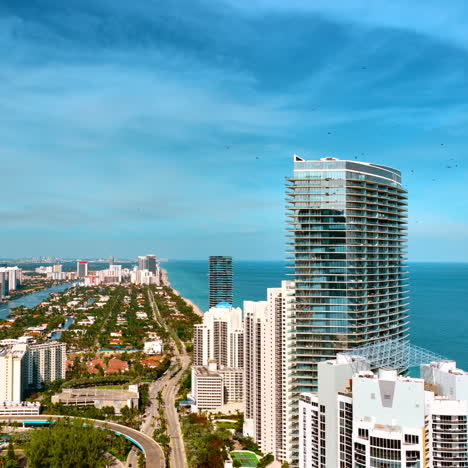 rising above the magnificent panorama of sunny hot miami beach on daytime. green urban area with splendid waterscape from top.