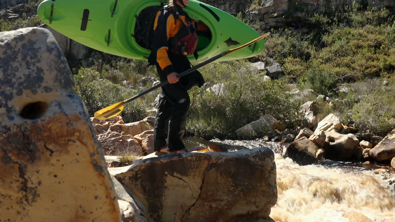 mujer con kayak y remo de pie cerca del río 4k