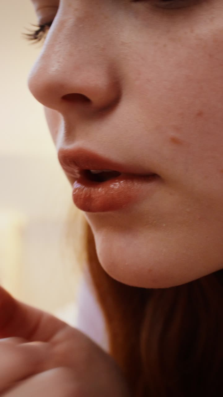 Woman applying lipstick close-up