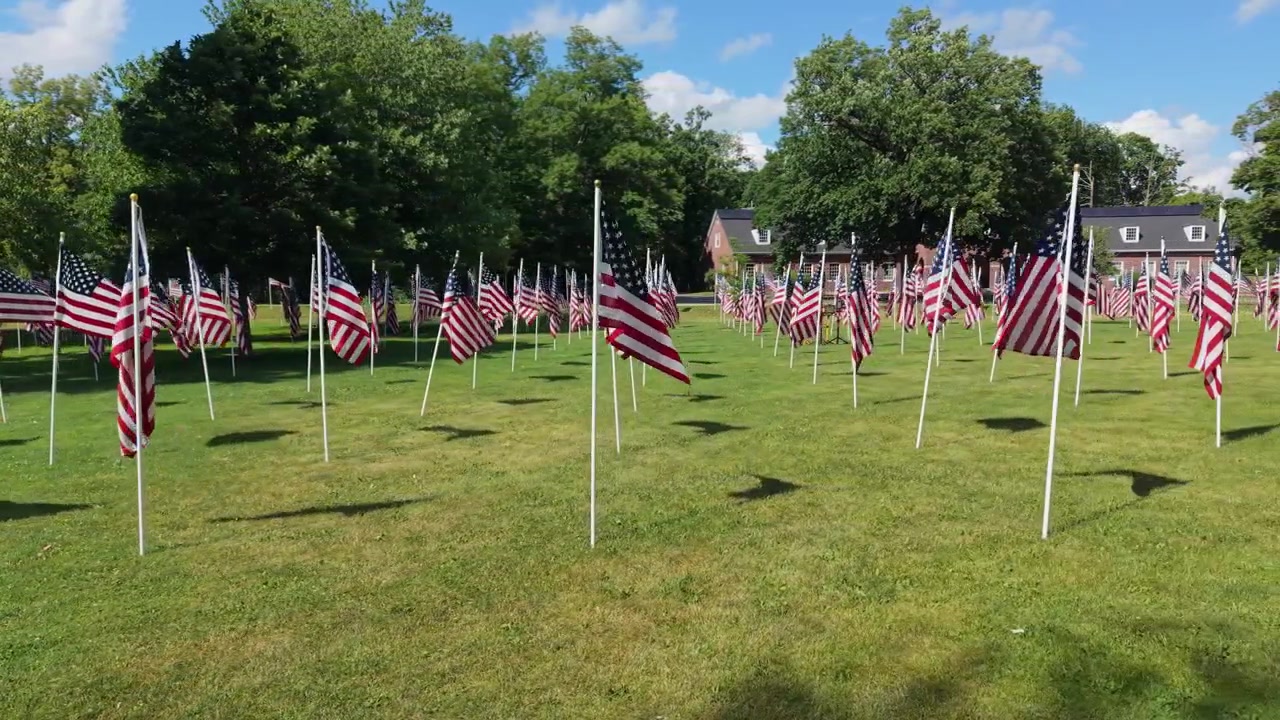 Drone panning fly of Patriots Memorial Park garden with number of American flags for patriotic displays in Independence Day, North Andover, Massachusetts, US