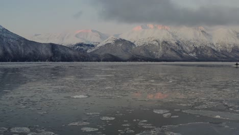 antena sobre agua semicongelada de cook inlet con montañas de alaska en segundo plano.