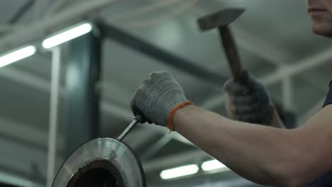 a man repairs the brake disc of an old car clamped in a vice