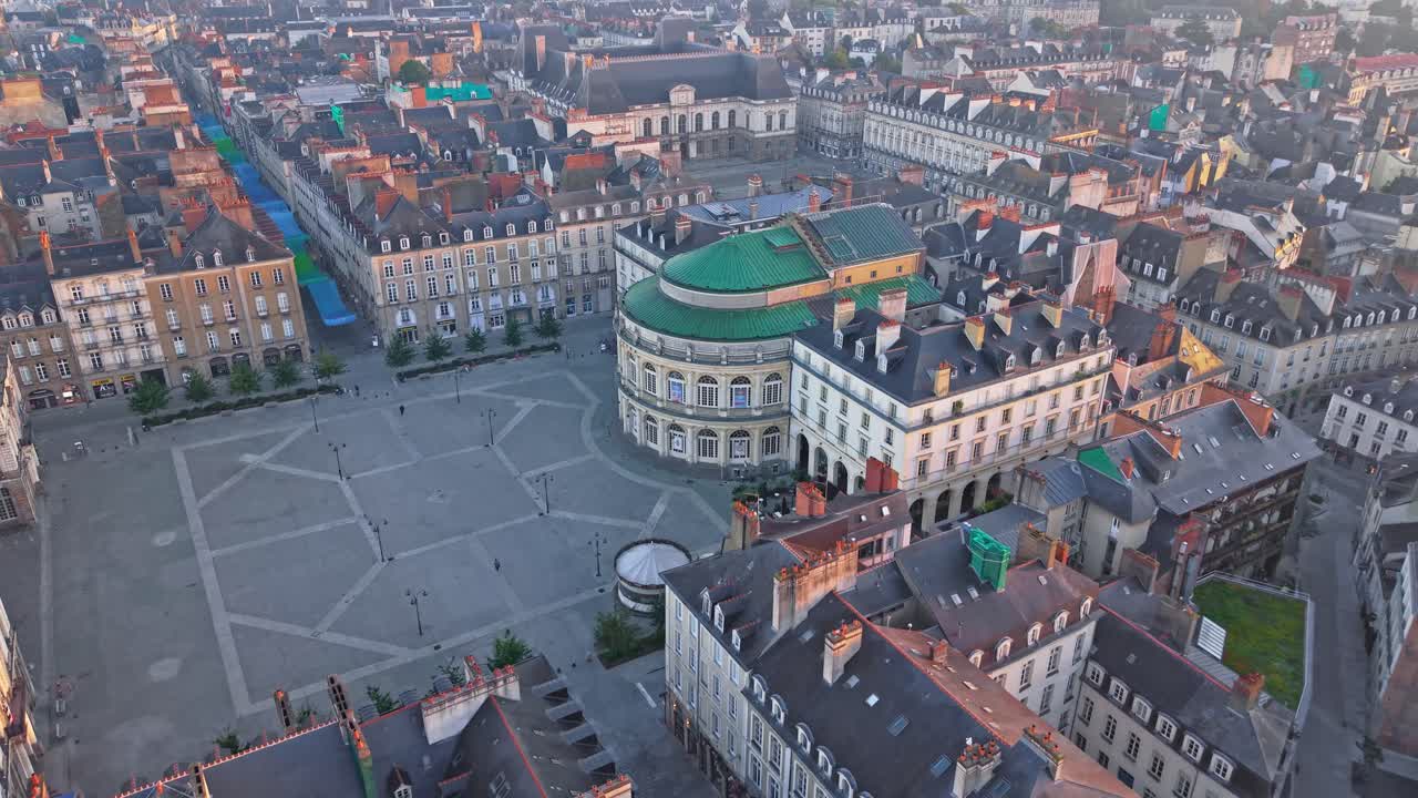 Drone advancing over Place de la Mairie toward Rennes Opera with the Parlement de Bretagne visible in the background in Rennes, France at sunrise
