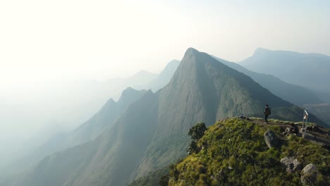 aerial drone shot of kolukkumalai range at dawn, shrouded in mist and early morning rays