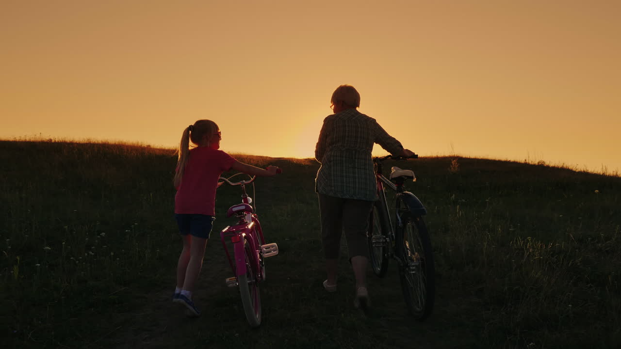 해질녘에 손녀 자전거와 함께 걷는 노부인 1