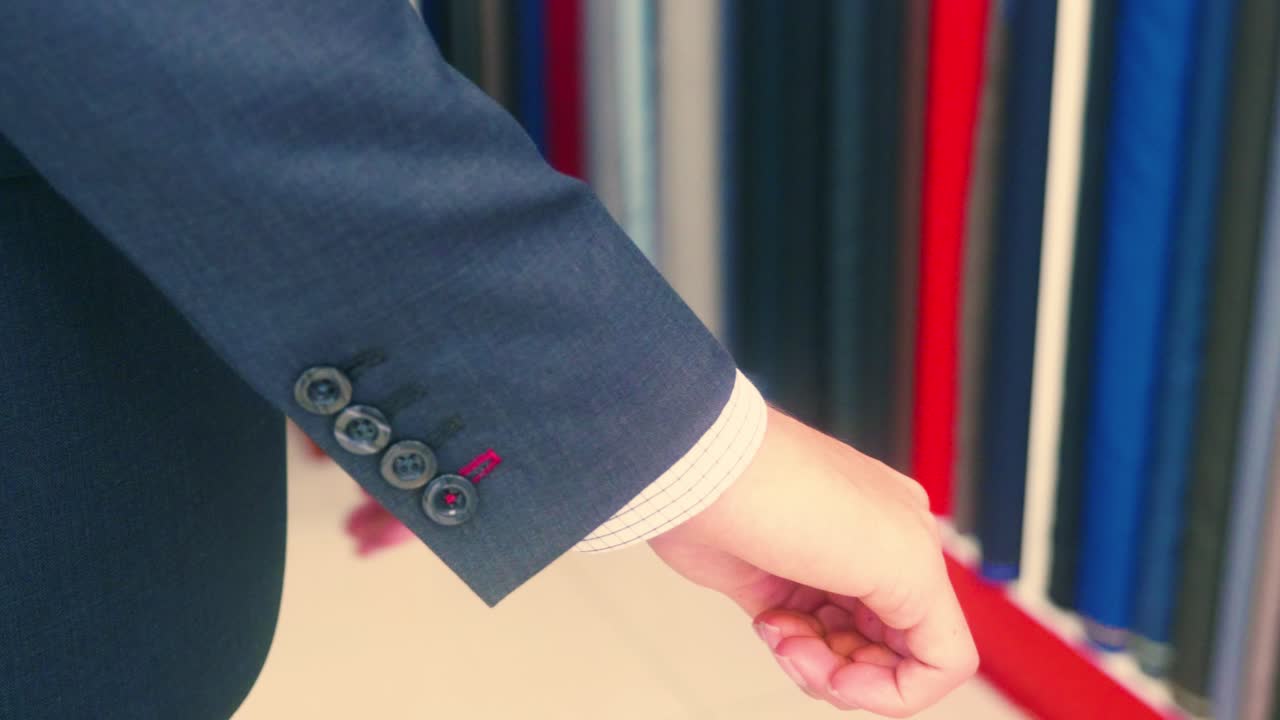 4K Cinematic fashion clothing footage of a model appreciating his new suit on in a tailor's shop