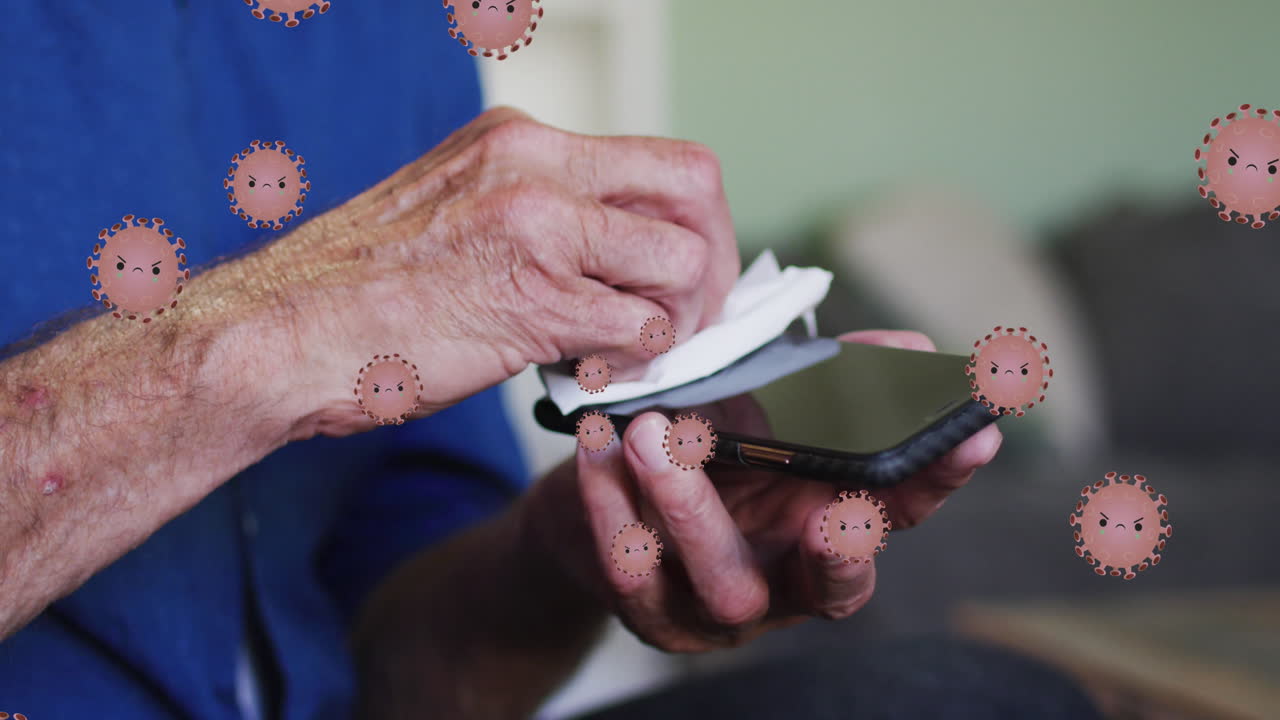 animación de células de virus sobre un hombre caucásico de edad desinfectando un teléfono inteligente