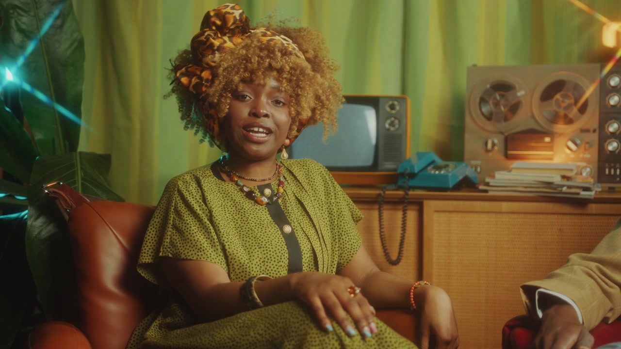 Afroameričtí spolumoderátoři hovořící do kamery v retro televizní show