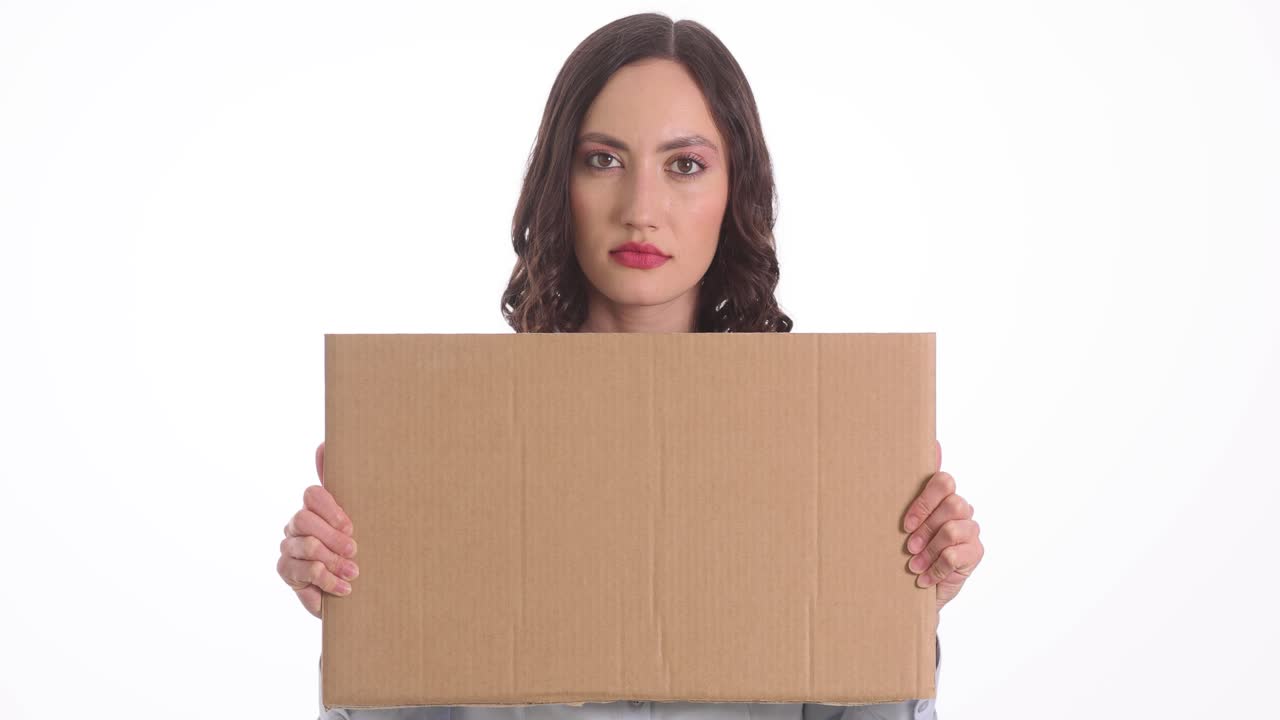 Joven mujer sosteniendo un cartel de cartón en blanco sobre fondo blanco
