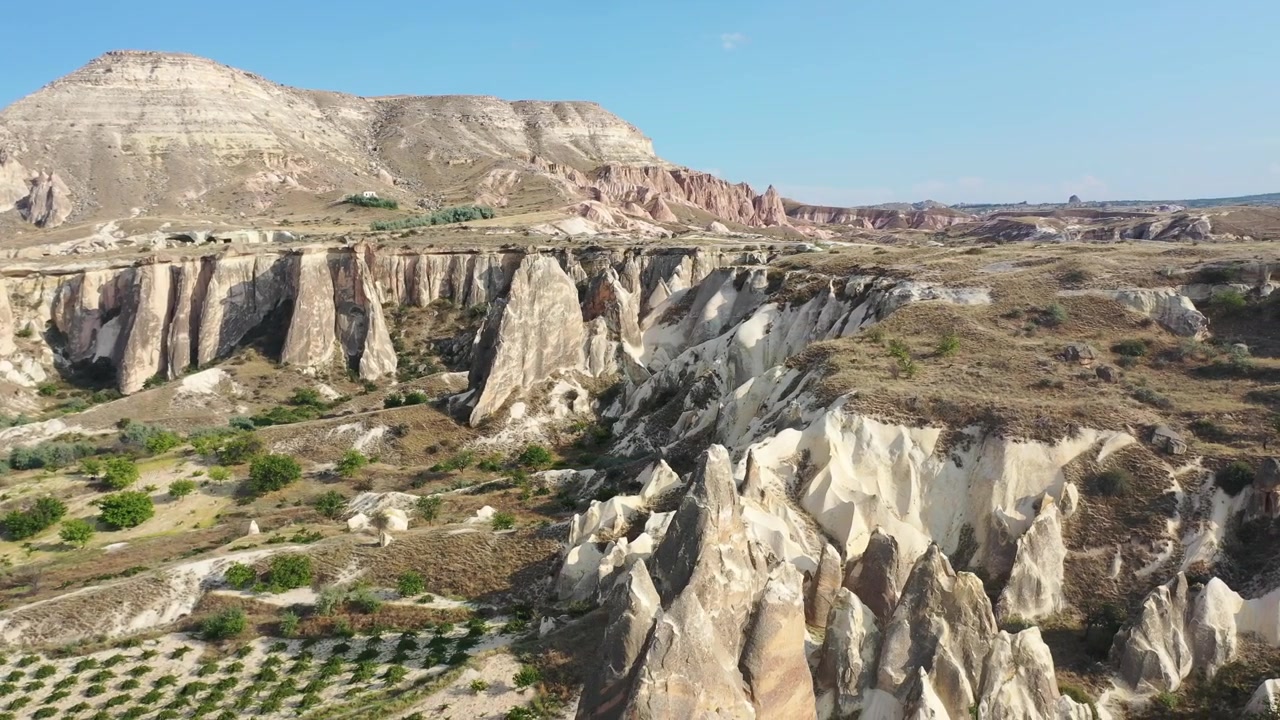 Ripresa aerea con drone dall'alto su migliaia di fitti e appuntiti camini delle fate e scogliere di arenaria stratificate nella Valle Rossa, Cappadocia, Nevsehir, Turchia, in una giornata di sole.
