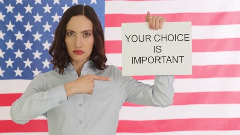 woman holding "your choice is important" sign in front of american flag