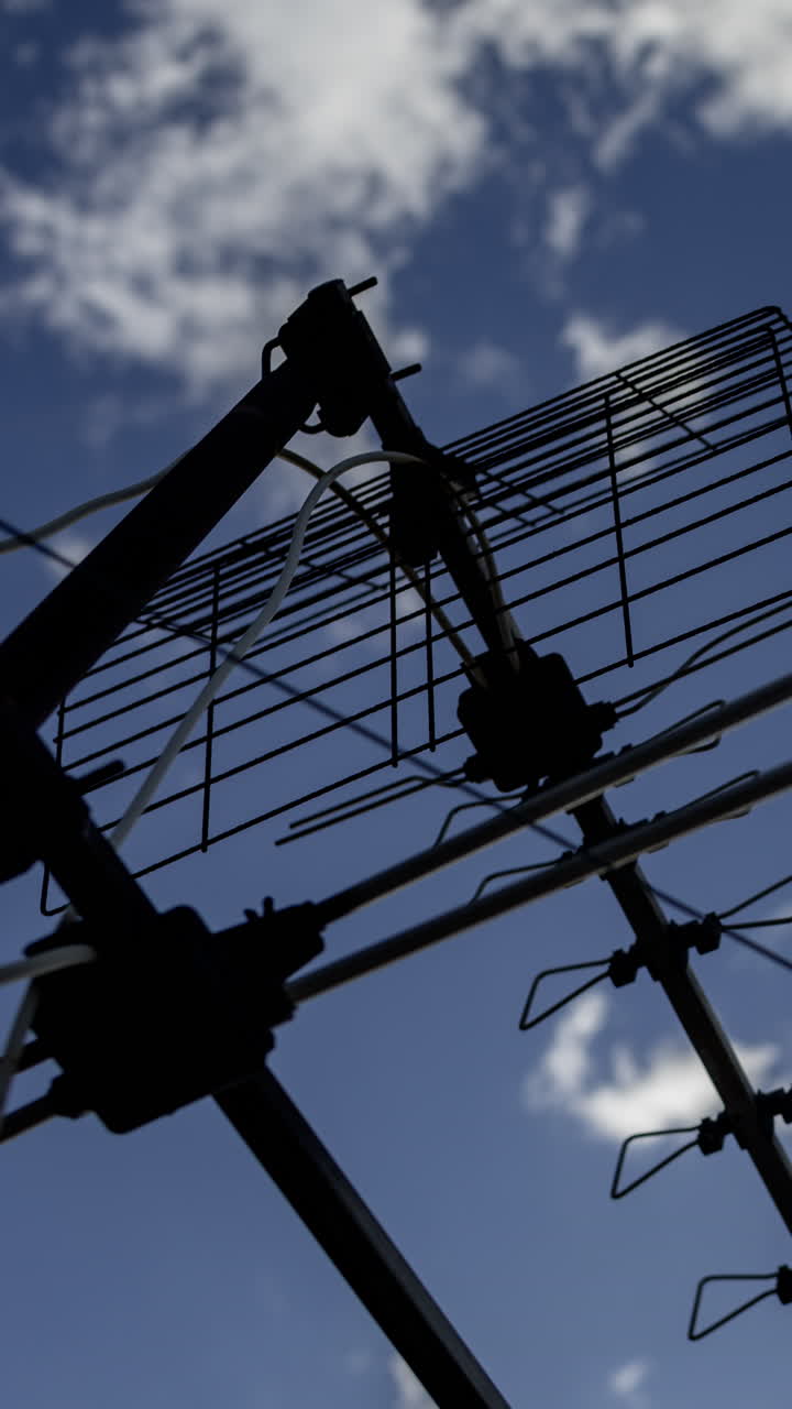 A timelapse of the sky and clouds with television aerials in the foreground