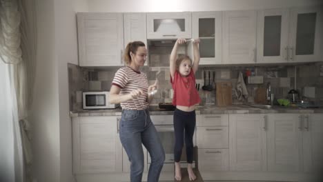 mother and daughter dancing in kitchen