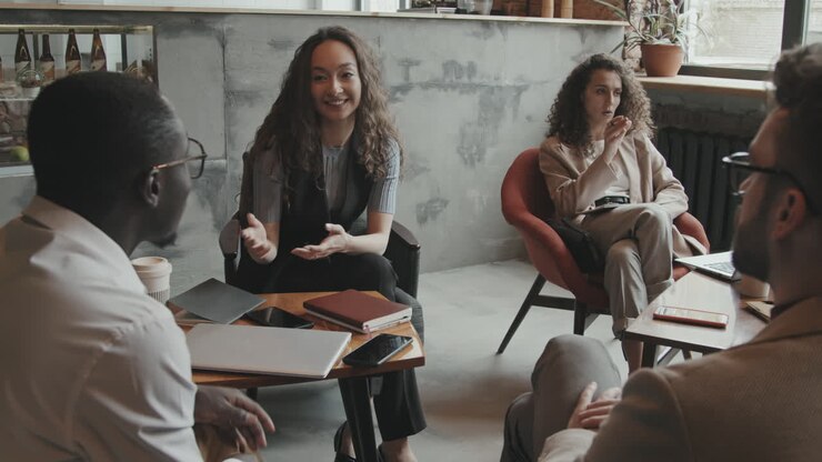 Unge kollegaer diskuterer arbejde i et coworking-kontor på et loft