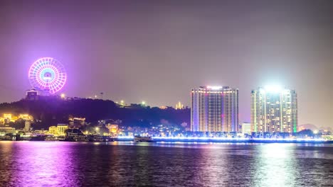 night view of city skyline with ferris wheel and illuminated buildings