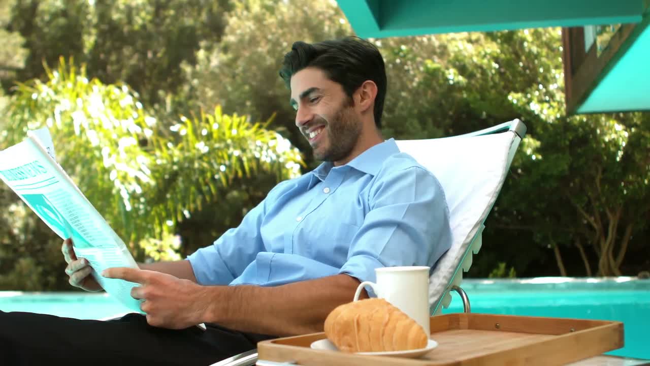 hombre de negocios leyendo el periódico en una silla de sol