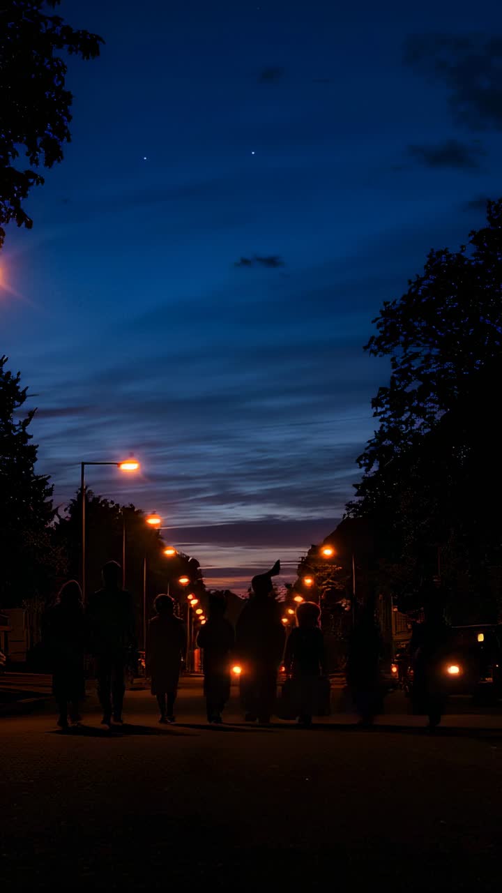 Vídeo vertical: el atardecer guía a niños disfrazados que caminan por una calle residencial con calabazas iluminadas