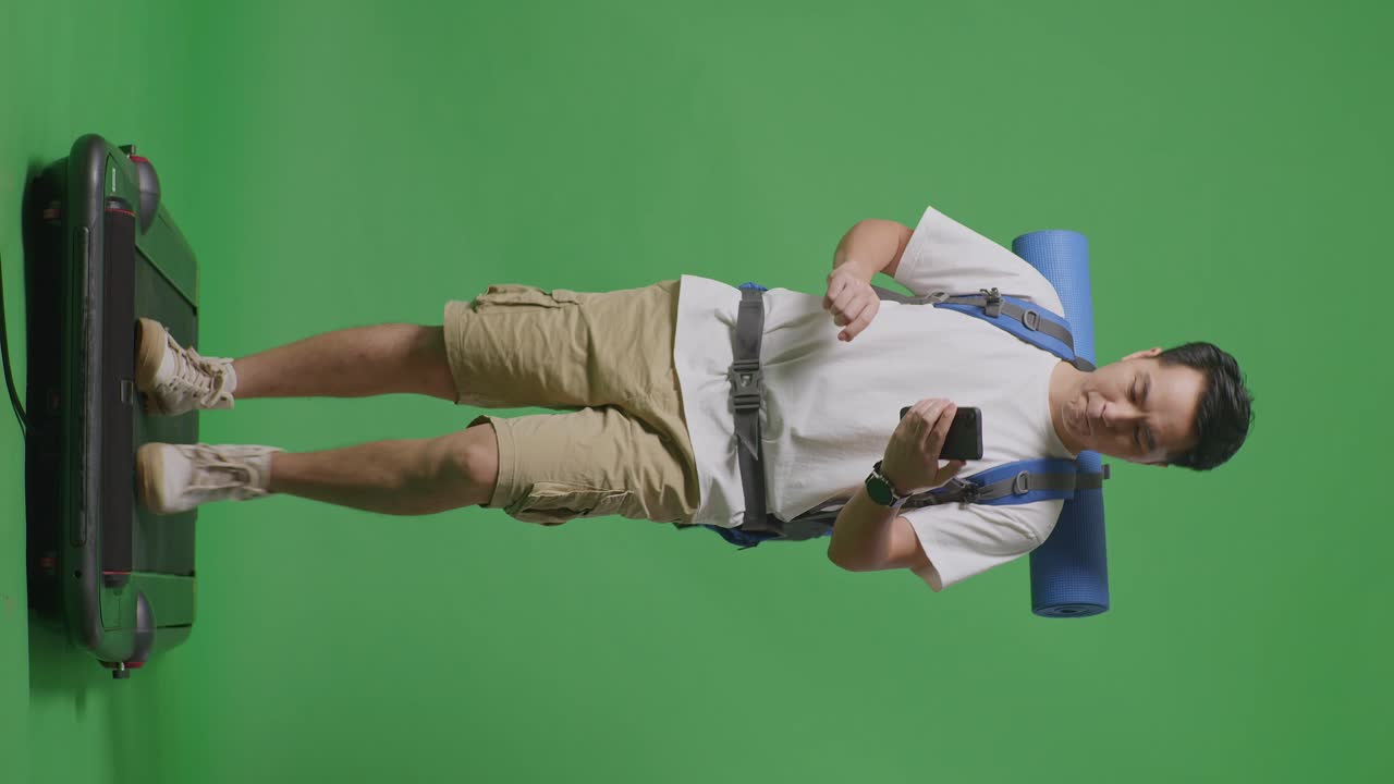 hombre usando el teléfono en una cinta de correr con una mochila