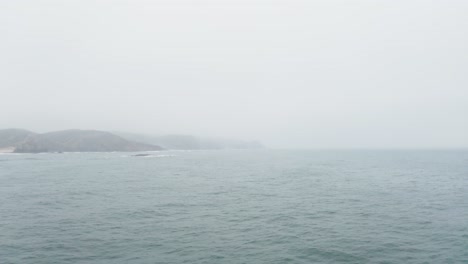 seascape with mountains silhouettes under overcast sky in portugal. - aerial shot