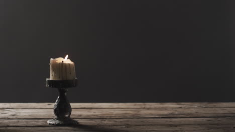 video de una vela de halloween con humo y espacio de copia sobre un fondo de madera y negro