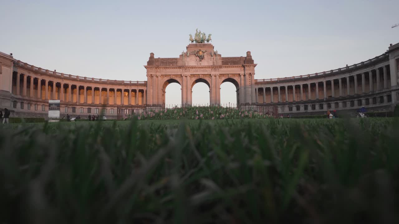 벨기에 브뤼셀의 parc du cinquantenaire에 있는 삼중 개선문 잔디에서 낮은 와이드 샷