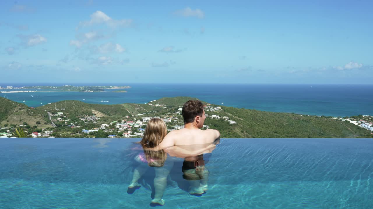 um casal de lua-de-mel romântico a relaxar na piscina infinita num dia ensolarado em saint martin.