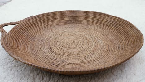 antique round wicker basket on a traditional moroccan berber carpet.