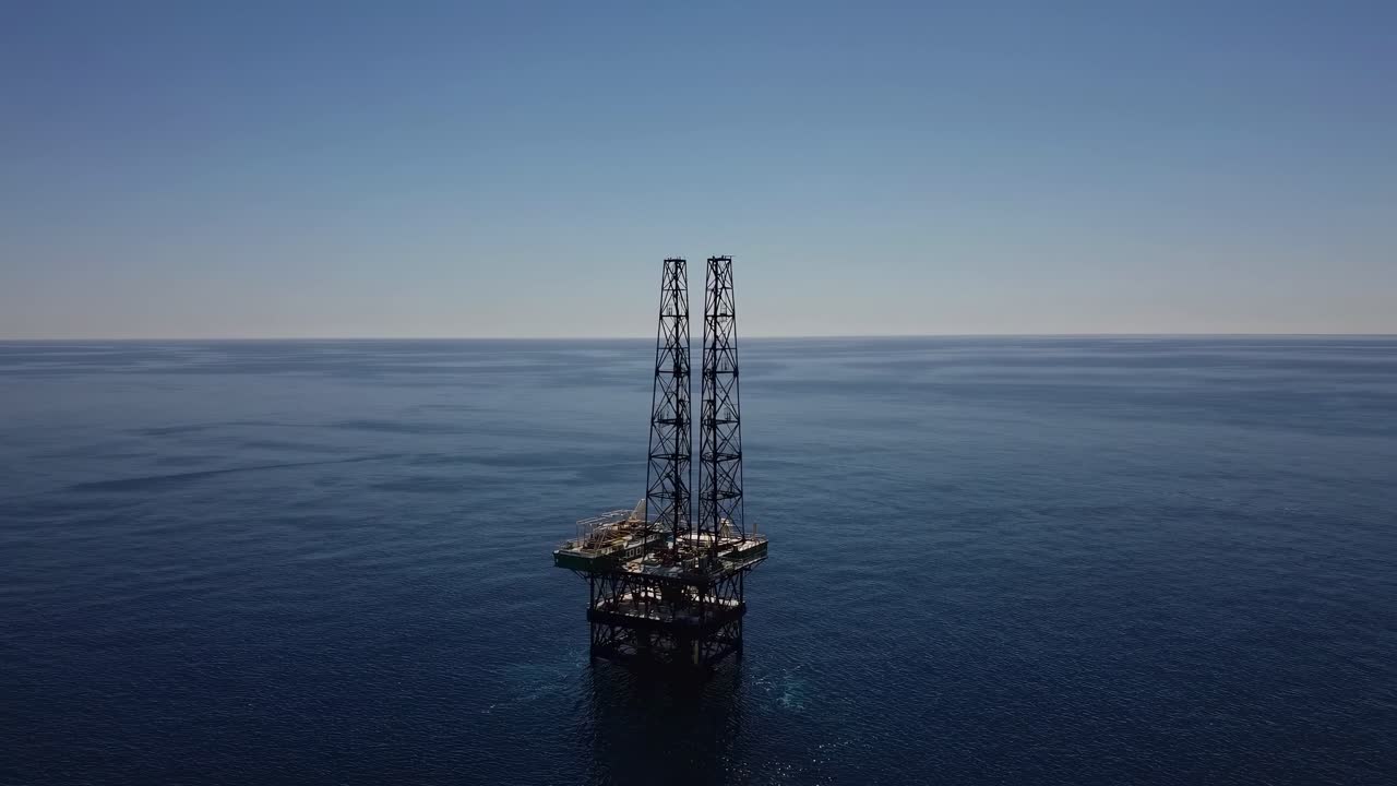 Offshore olieplatform stående i et roligt blåt hav under en klar himmel
