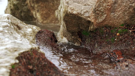 waves in slow motion hitting the rocky shore and crashing with power