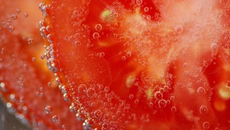 rebanadas de tomate bajo el agua con burbujas de aire.