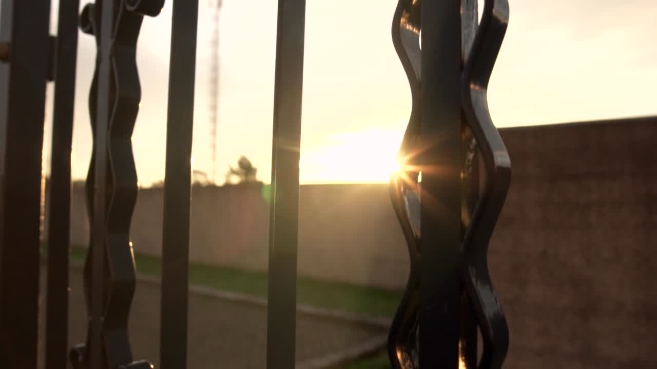 puesta de sol a través de una valla de metal ornamental