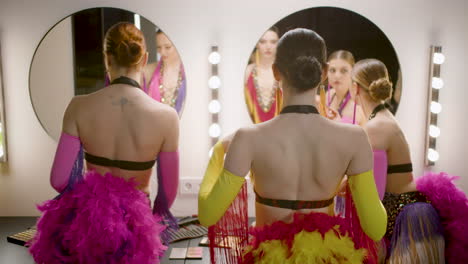 three showgirls getting ready in the backstage