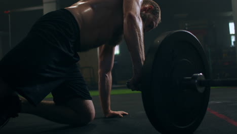 A-strong-man-is-pressed-on-one-hand-in-the-gym-with-a-vapor-on-his-body.