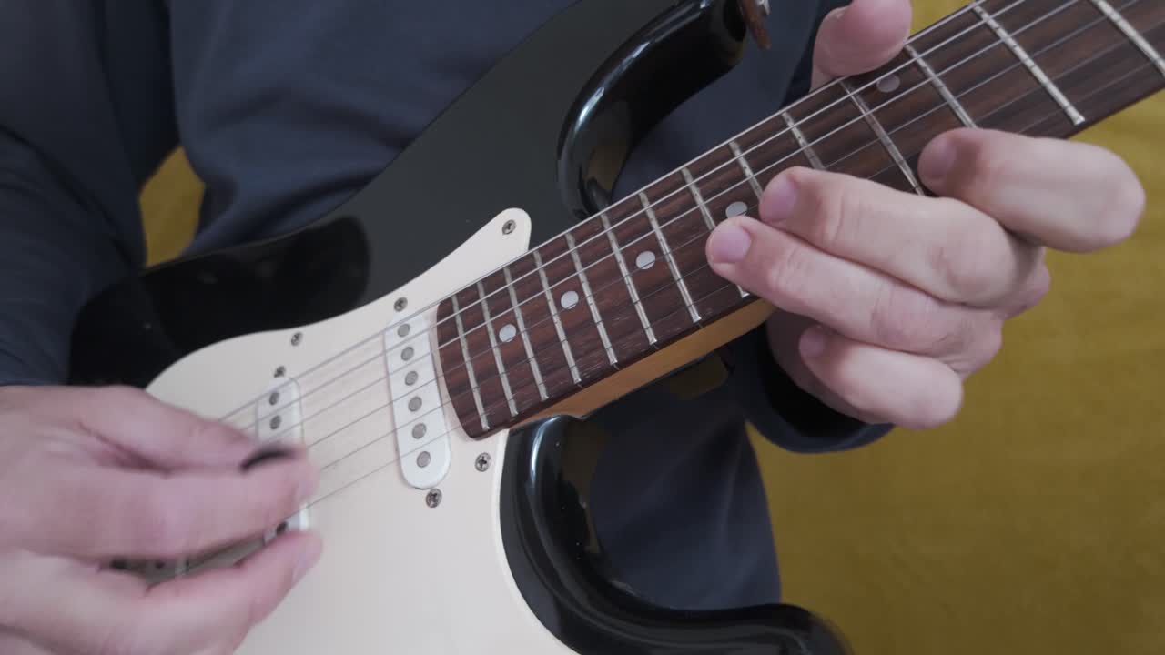 Musician strumming an electric guitar with ornate details and expressive movements.